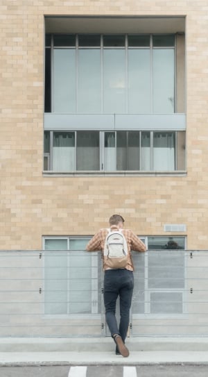man standing infront of building during daytime thumbnail