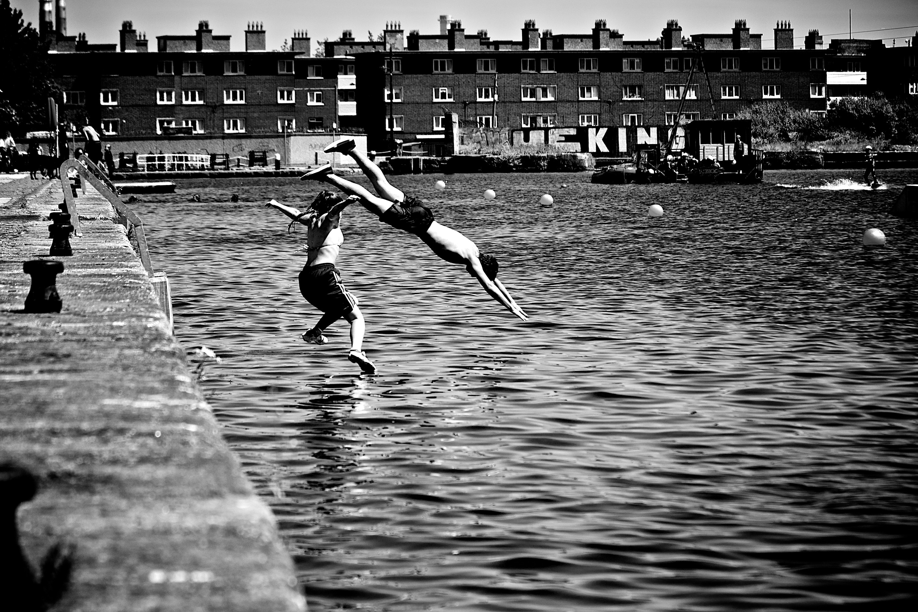 two person jumping in bodies of water