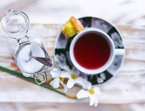 shallow focus photography of sugar with spoon and red liquid filled white mug thumbnail
