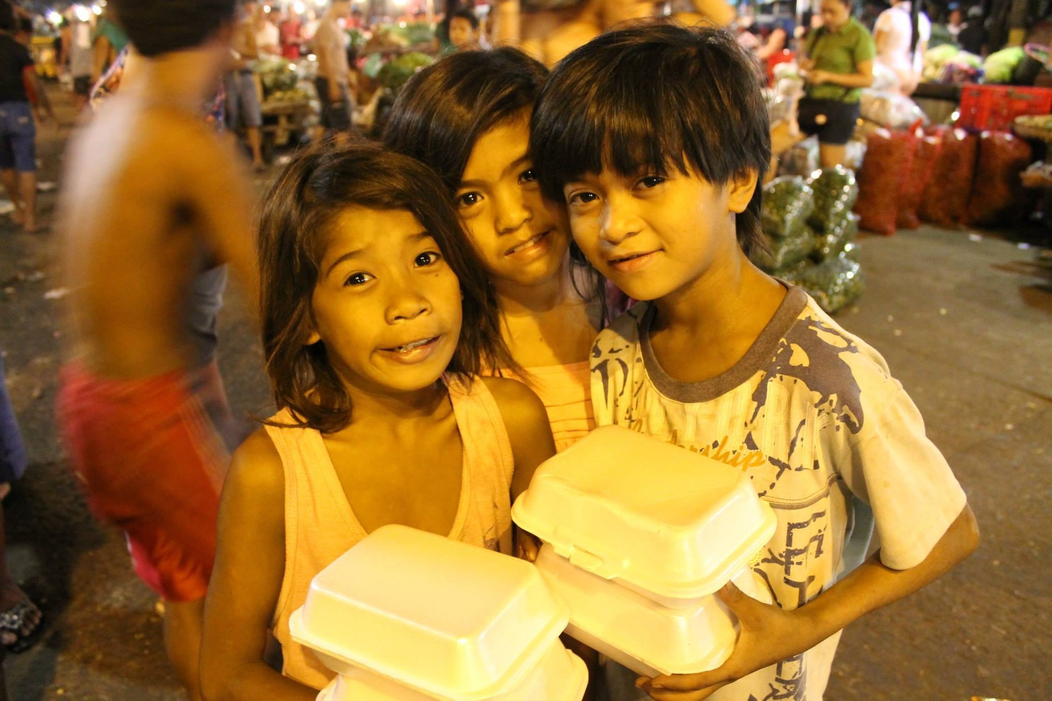 2 girl and boy holding white styro food container