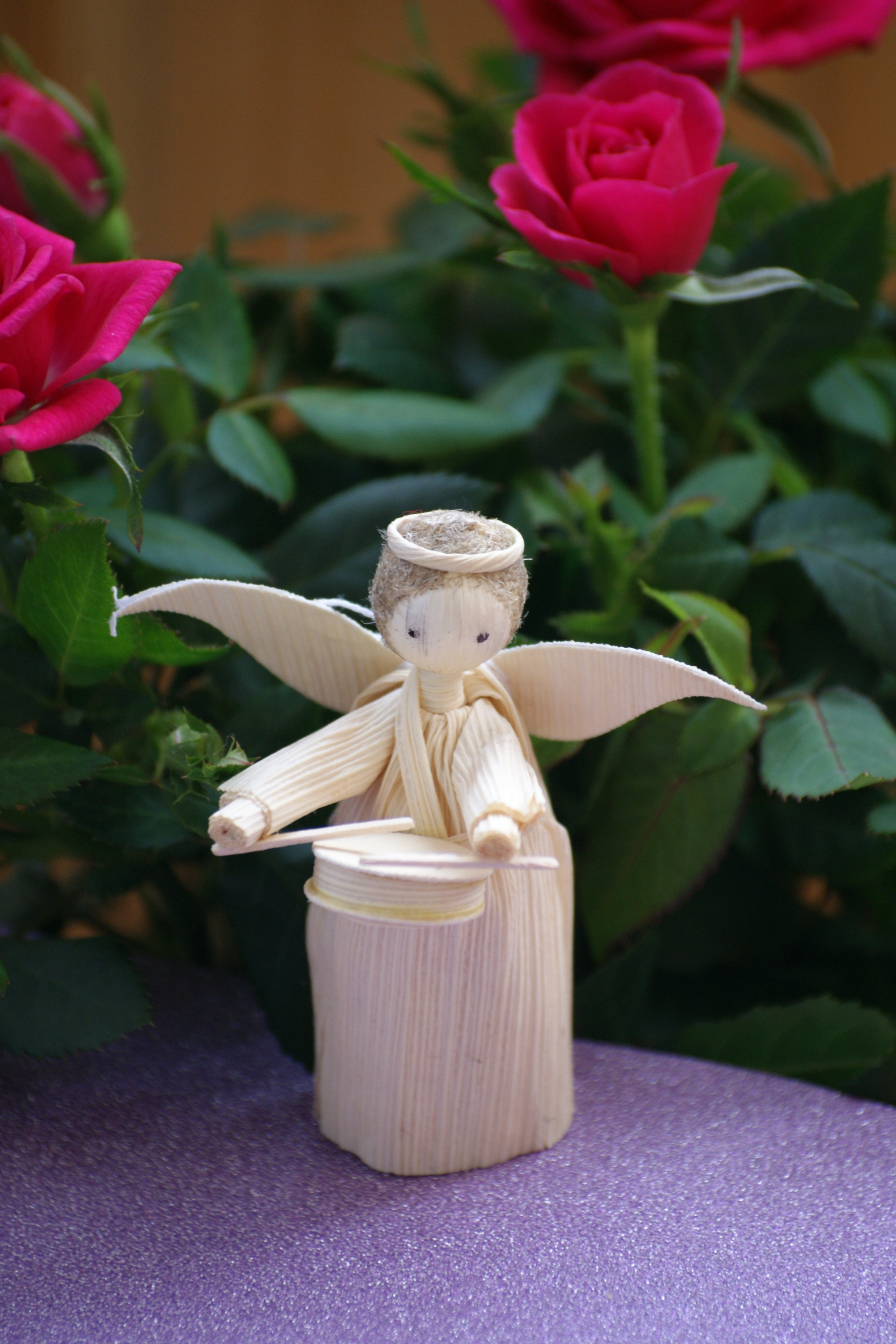 beige angel playing drum stick figurine