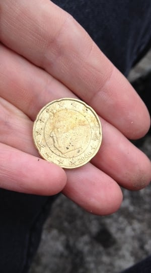 person holding round coin thumbnail