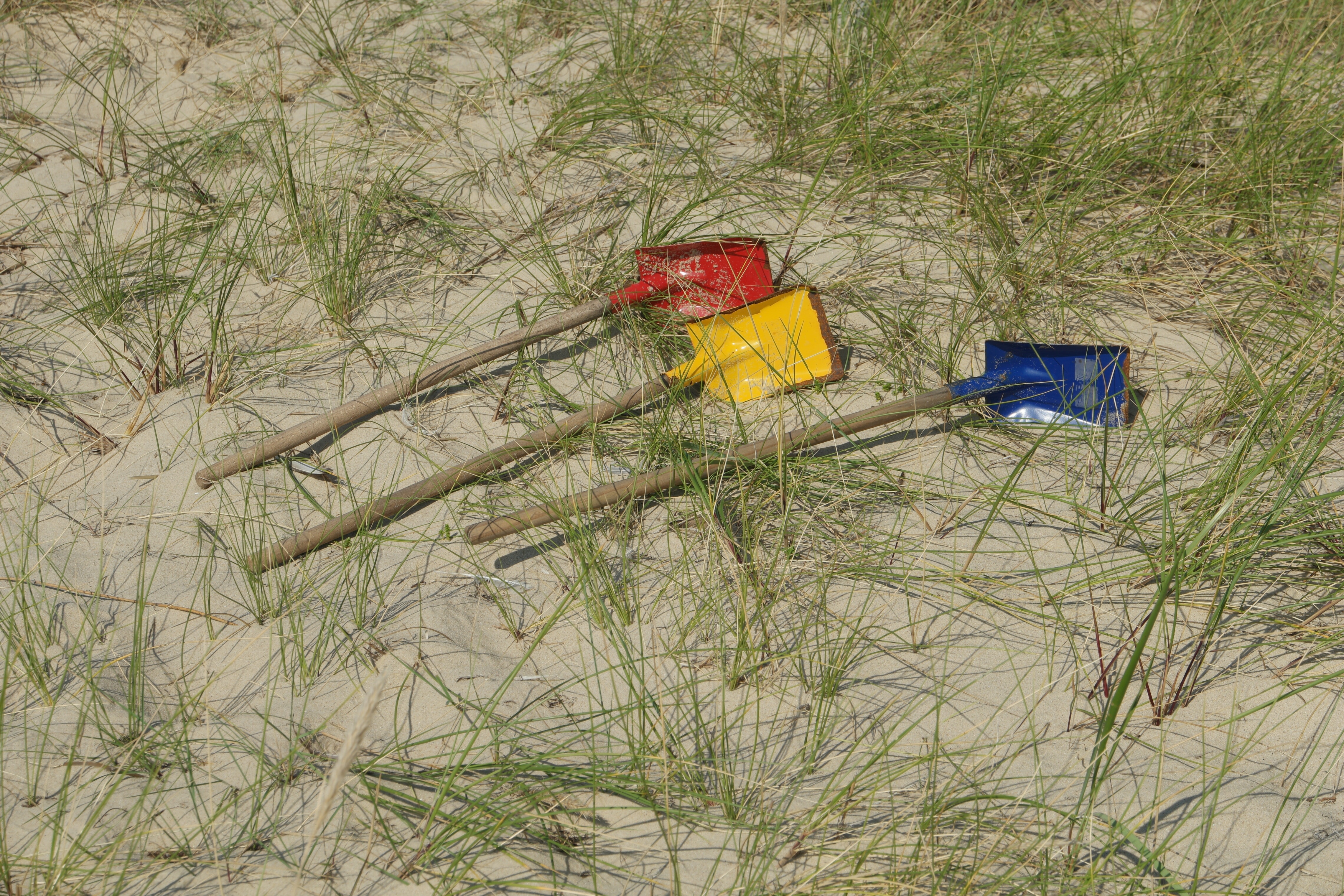 3 red yellow and blue shovels
