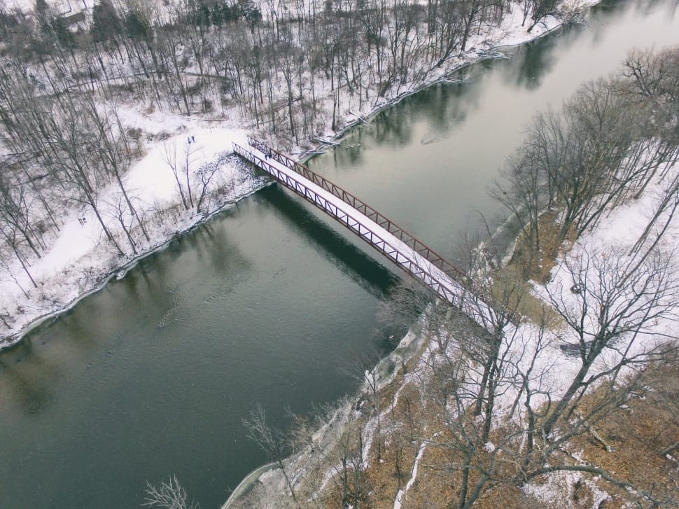 aerial photography of red metal bridge with road coated with snow preview