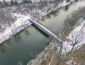 aerial photography of red metal bridge with road coated with snow thumbnail