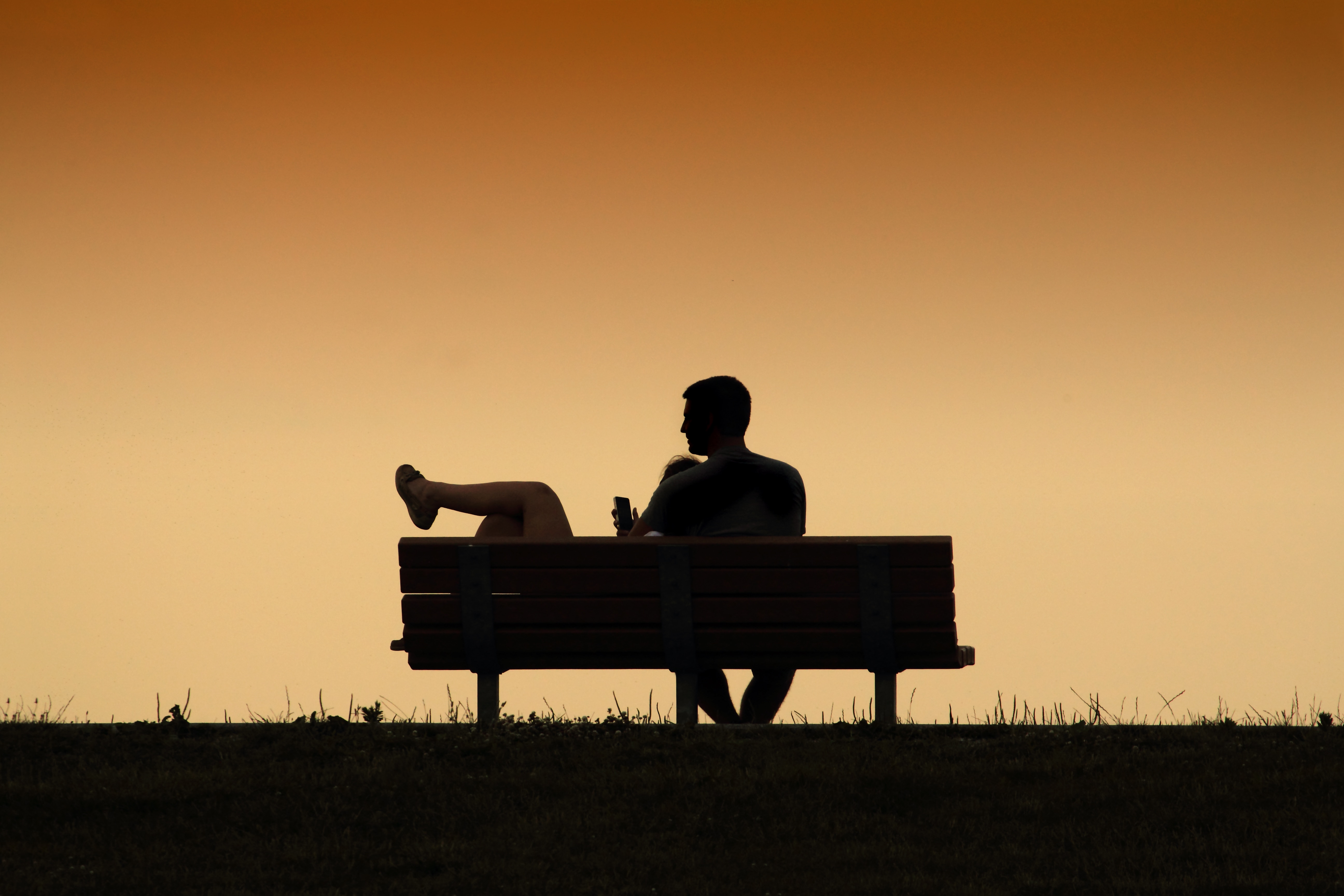 silhouette of man sitting on bench