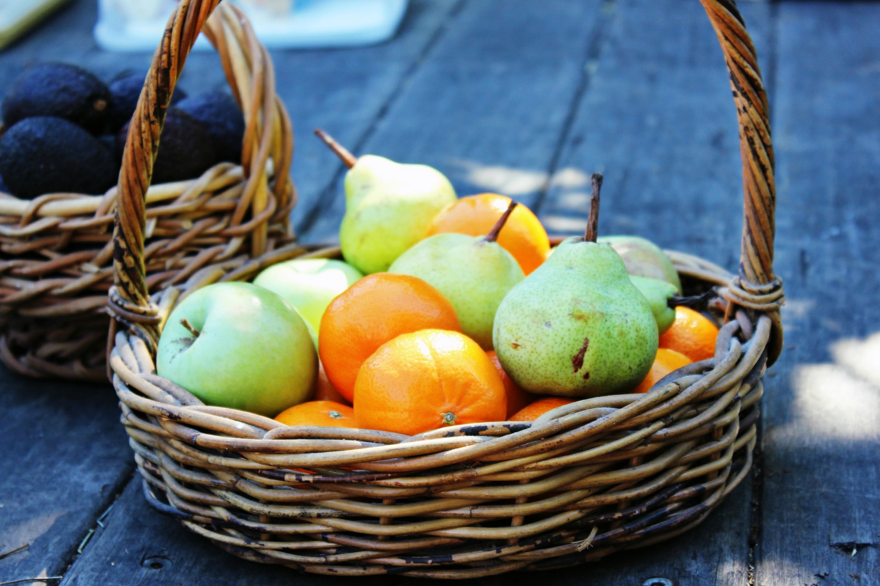 brown wicker basket with peaches apples and oranges