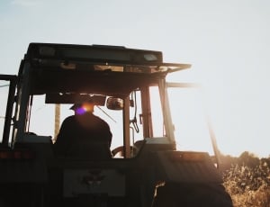 silhouette of man riding on a tractor during daytime thumbnail