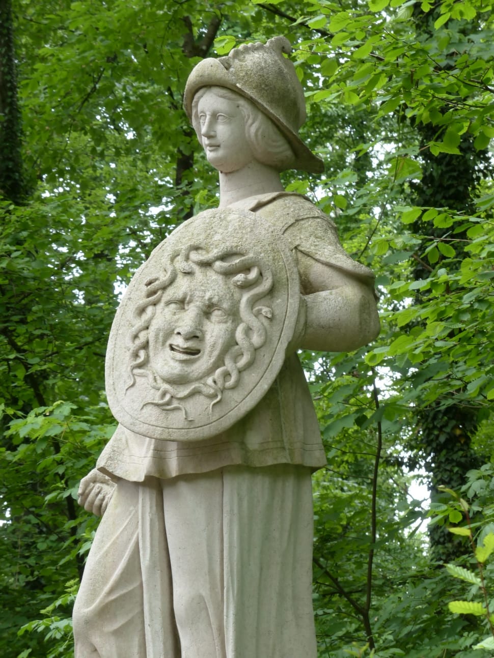 person in robe holding shield medusa carved statue preview