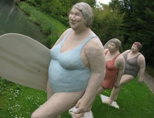 three woman in monokini carrying surfboards statue thumbnail
