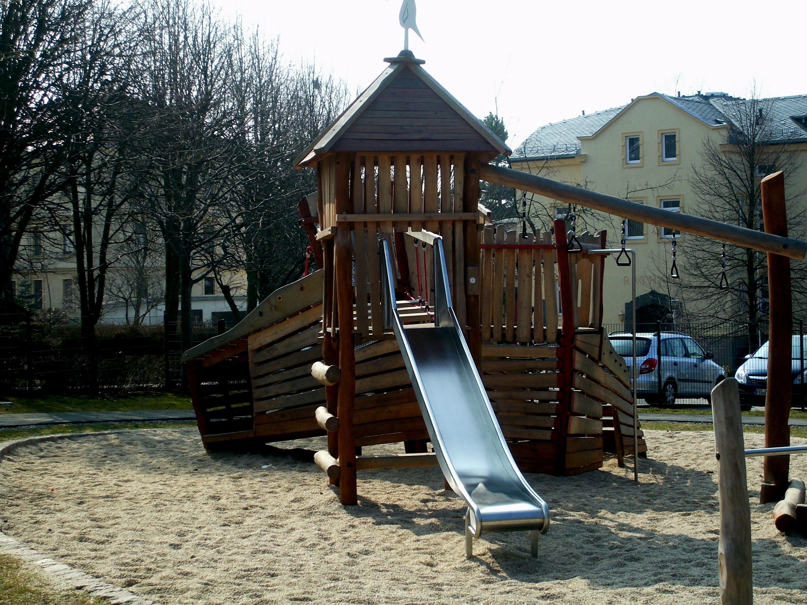 brown wooden swing and slide set