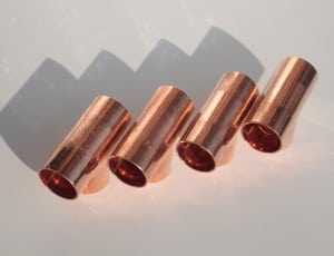 four brass canisters on white surface thumbnail