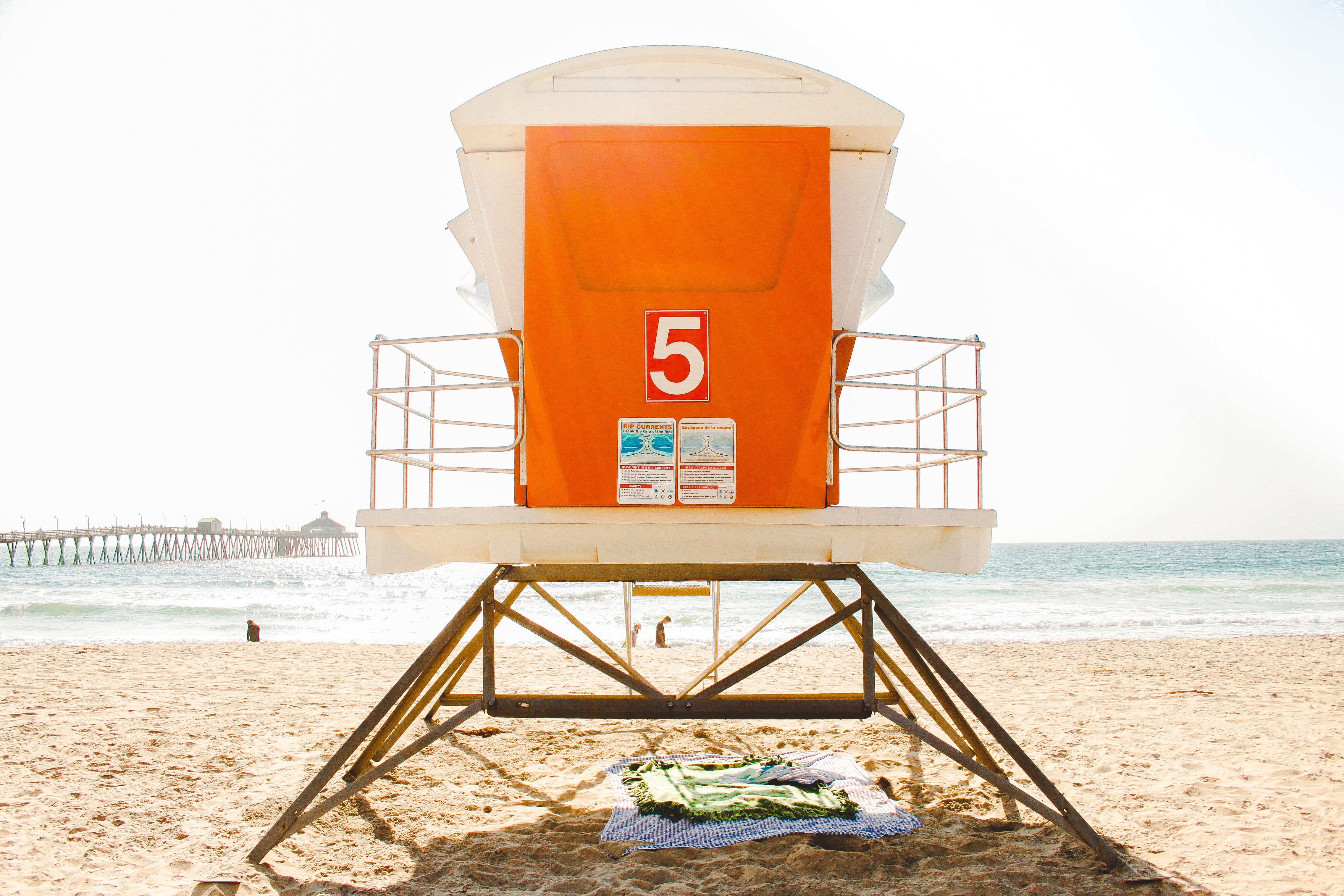 white and orange lifeguard post near seashore during daytime