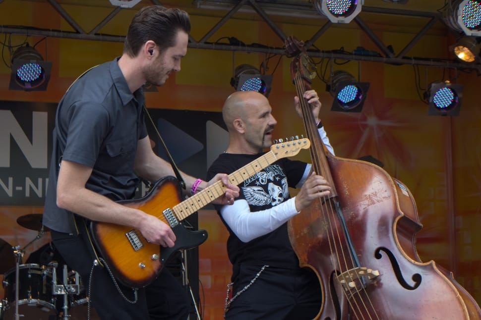 man playing sunburst electric guitar beside man playing cello preview