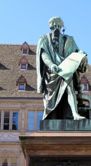 concrete man holding a scroll statue thumbnail