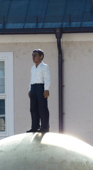 man in white long sleeve shirt and black pants statue thumbnail