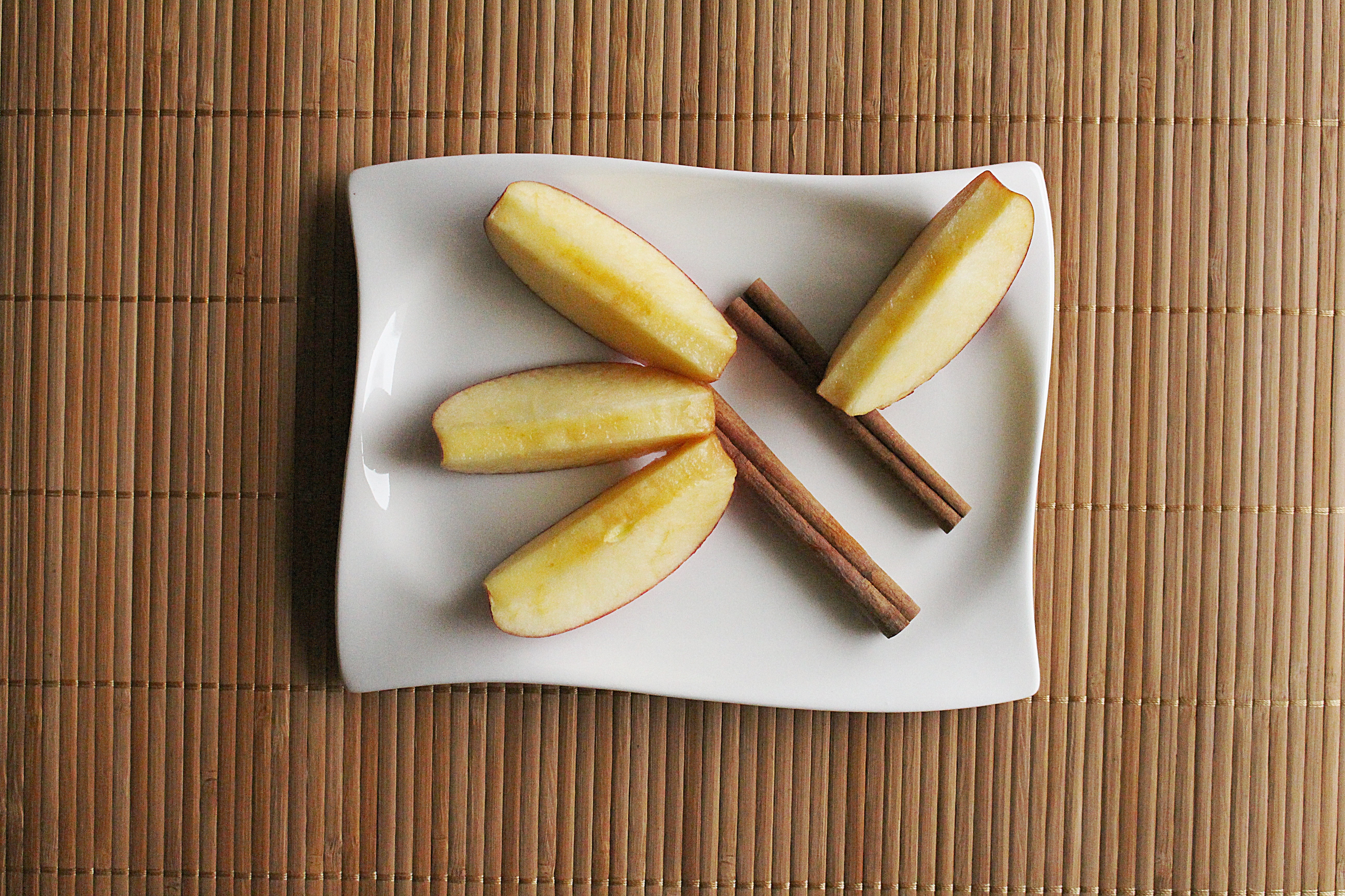 white rectangular ceramic plate with slice apple and sticks