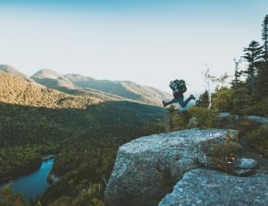 person jump peak of mountain during daytime photo thumbnail