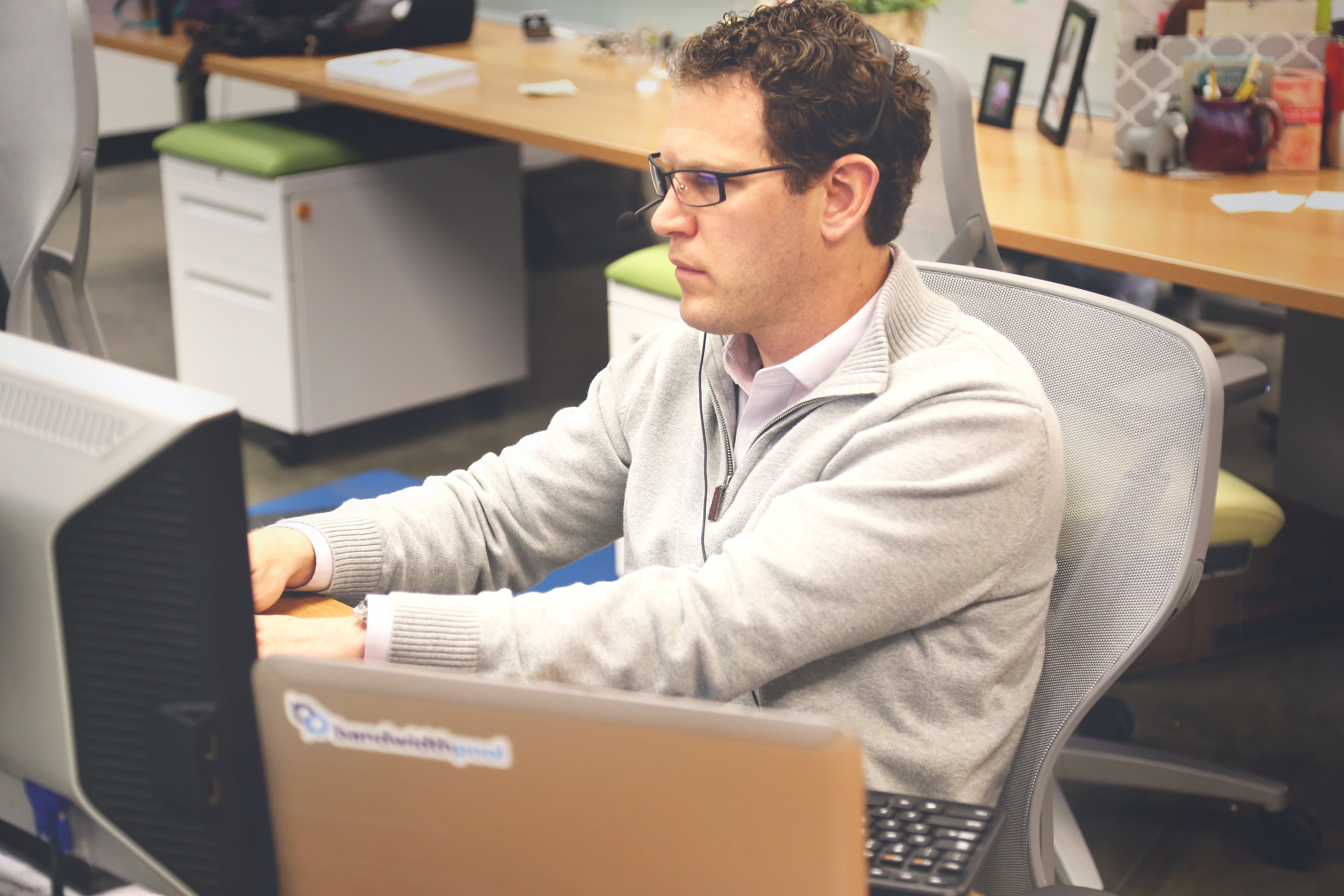 man wearing gray jacket using computer