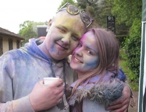 couple with color powder all over face and shirts embracing at daytime thumbnail