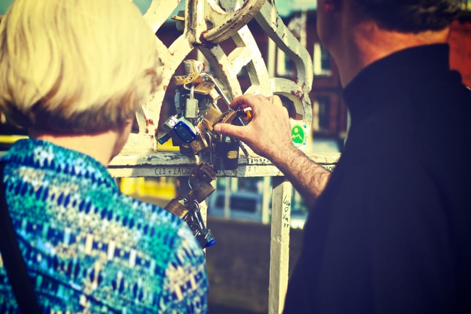 man and woman holding a padlock during daytime preview