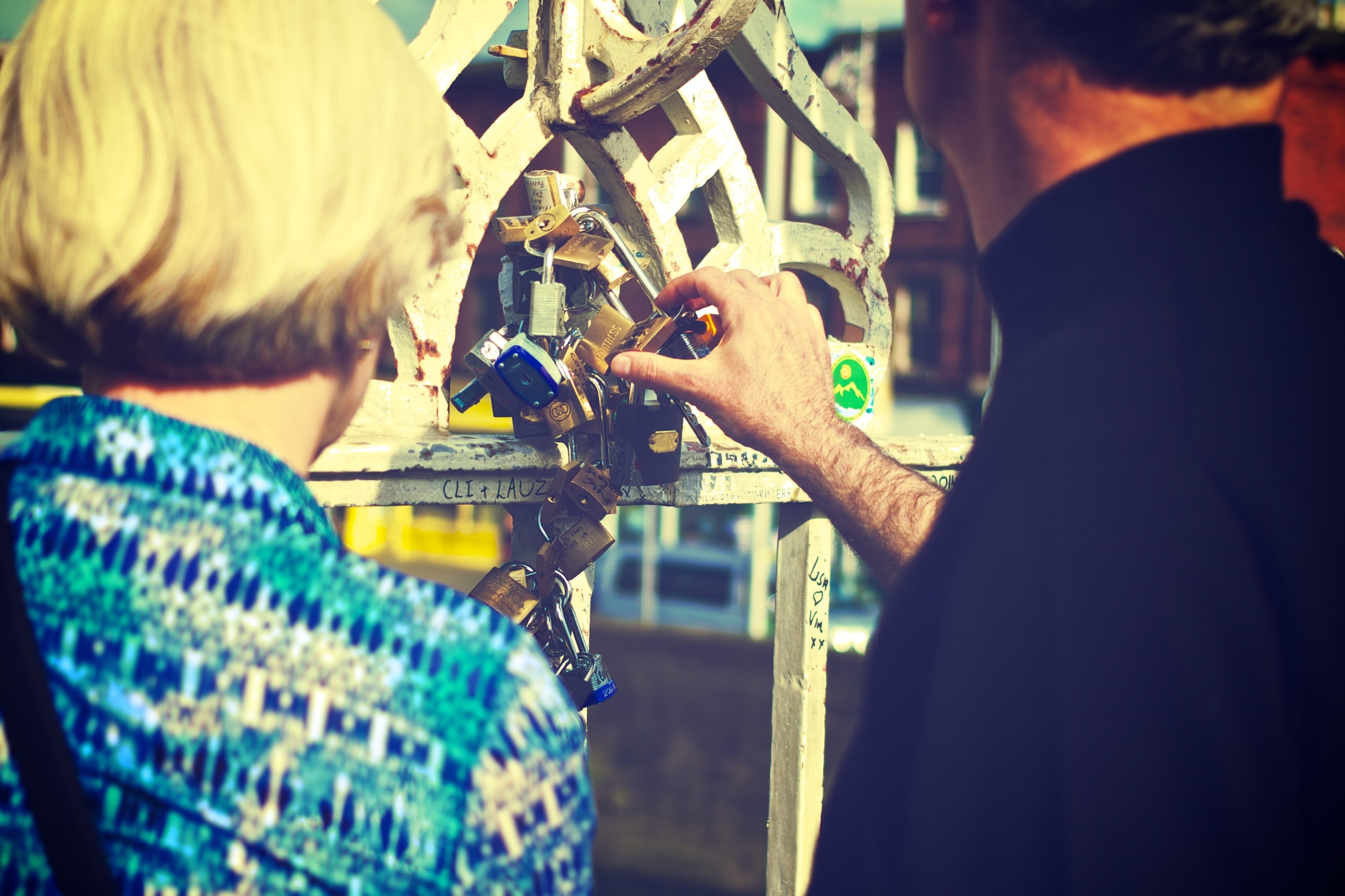 man and woman holding a padlock during daytime