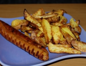 fried potatoes and cooked sausage on blue ceramic plate thumbnail
