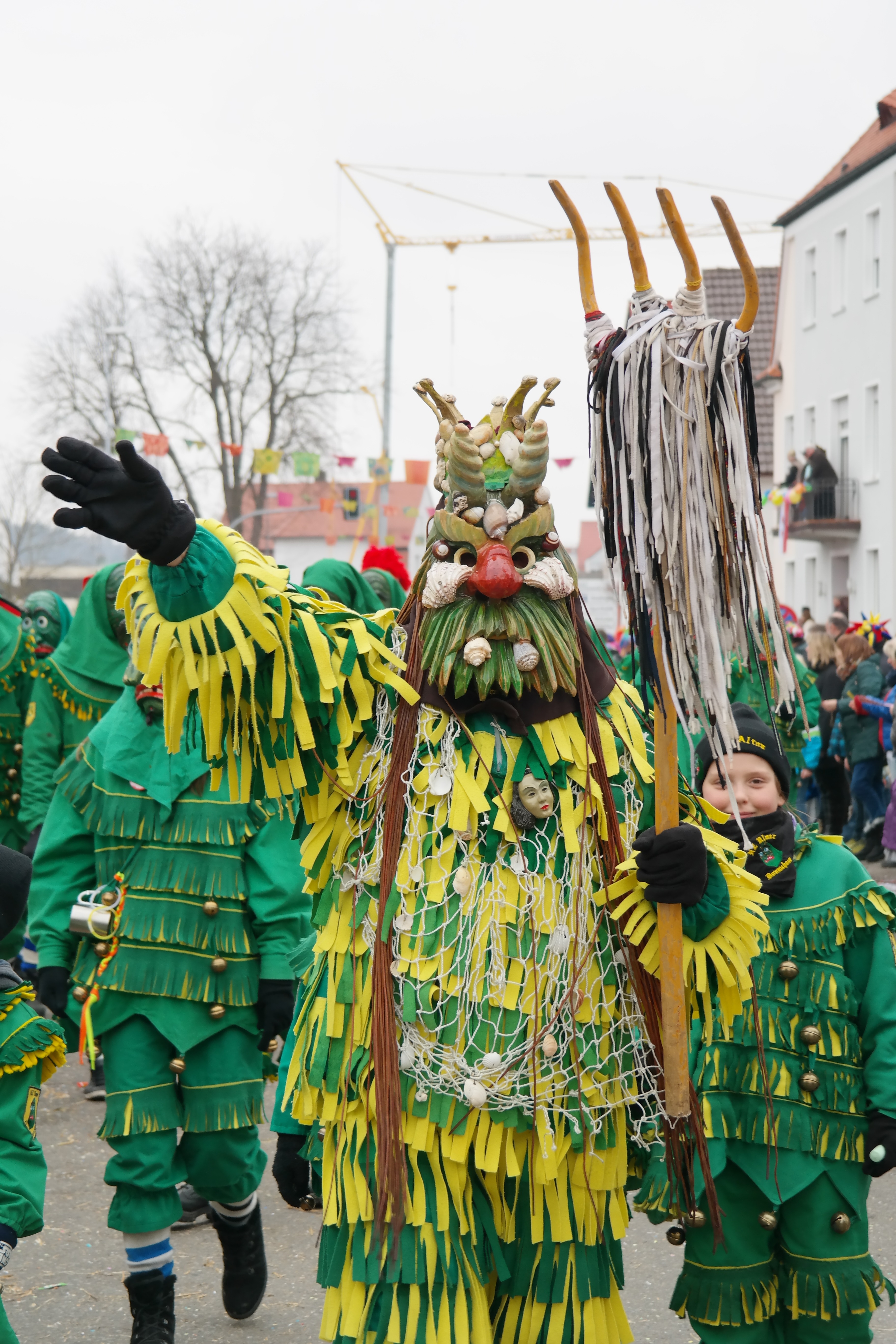 person wearing green and yellow rooster costume