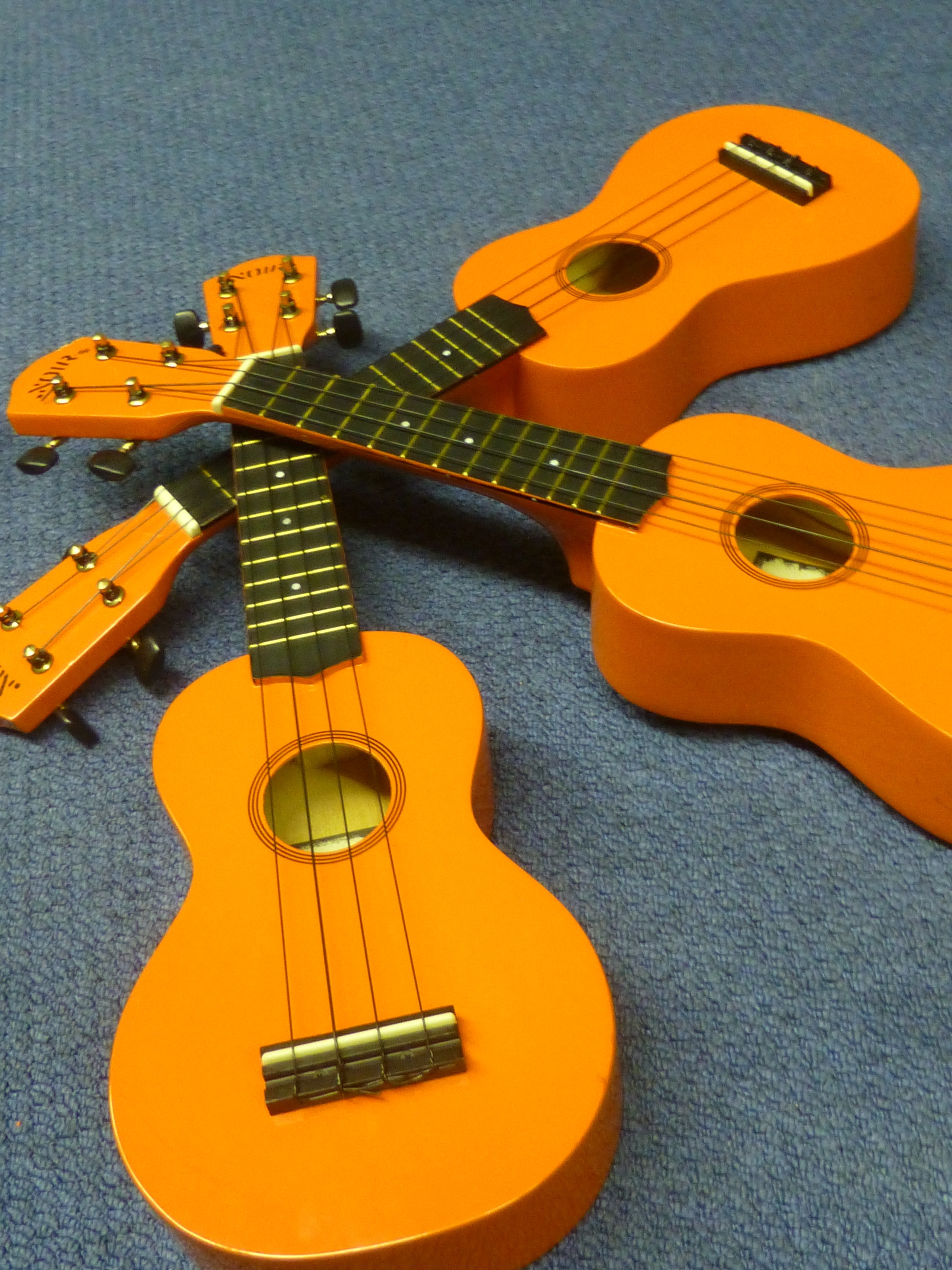 3 brown and black ukuleles