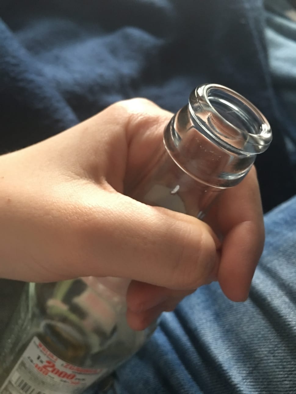 human holding clear glass bottle preview