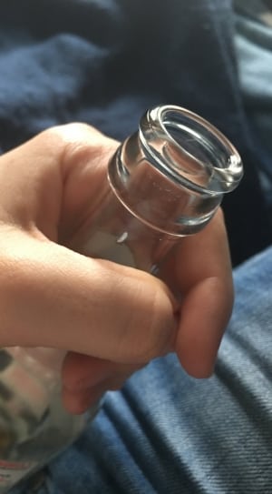 human holding clear glass bottle thumbnail