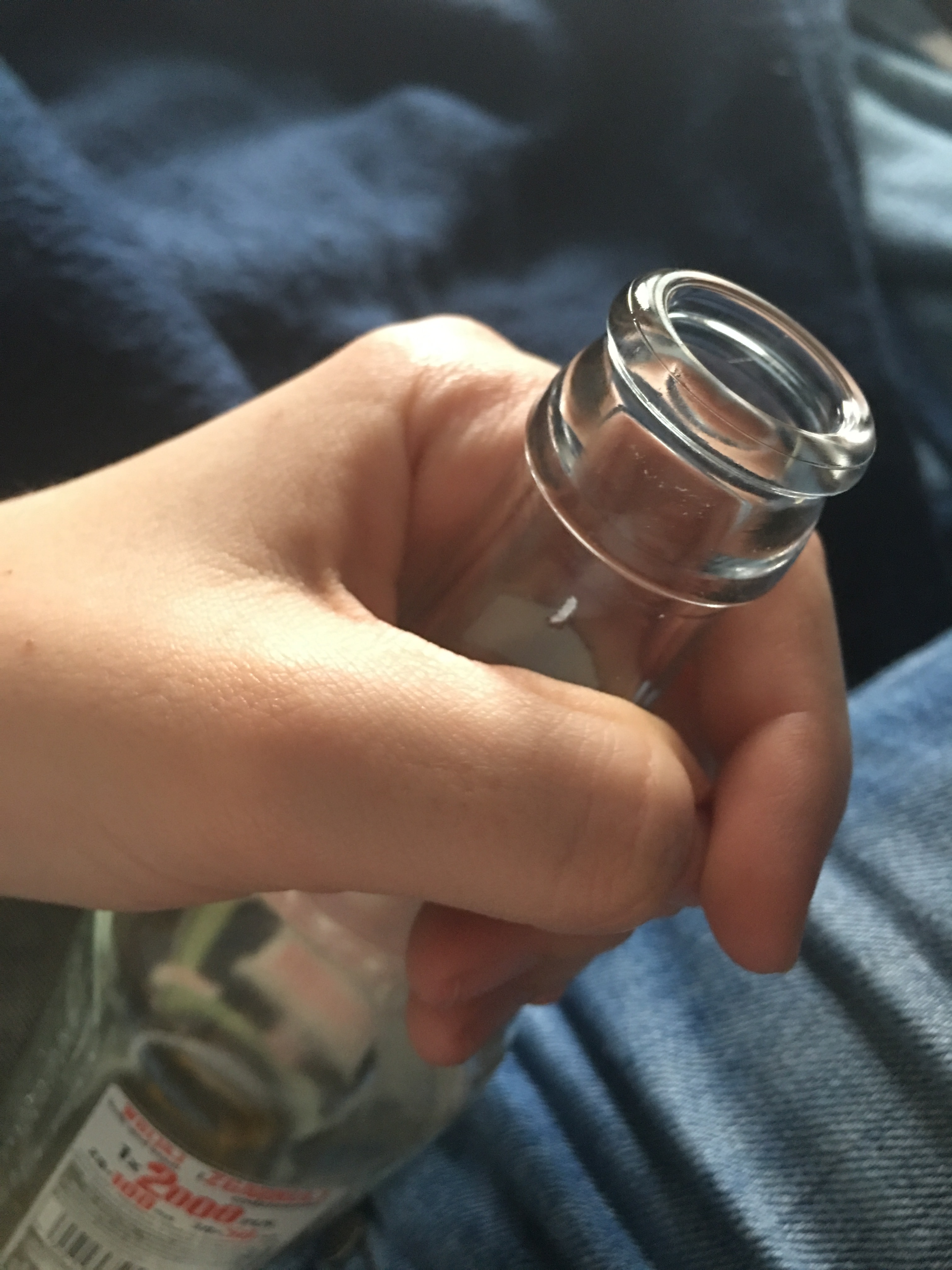 human holding clear glass bottle