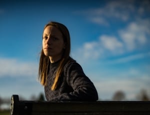 selective focus photography of a woman sitting on a bench thumbnail