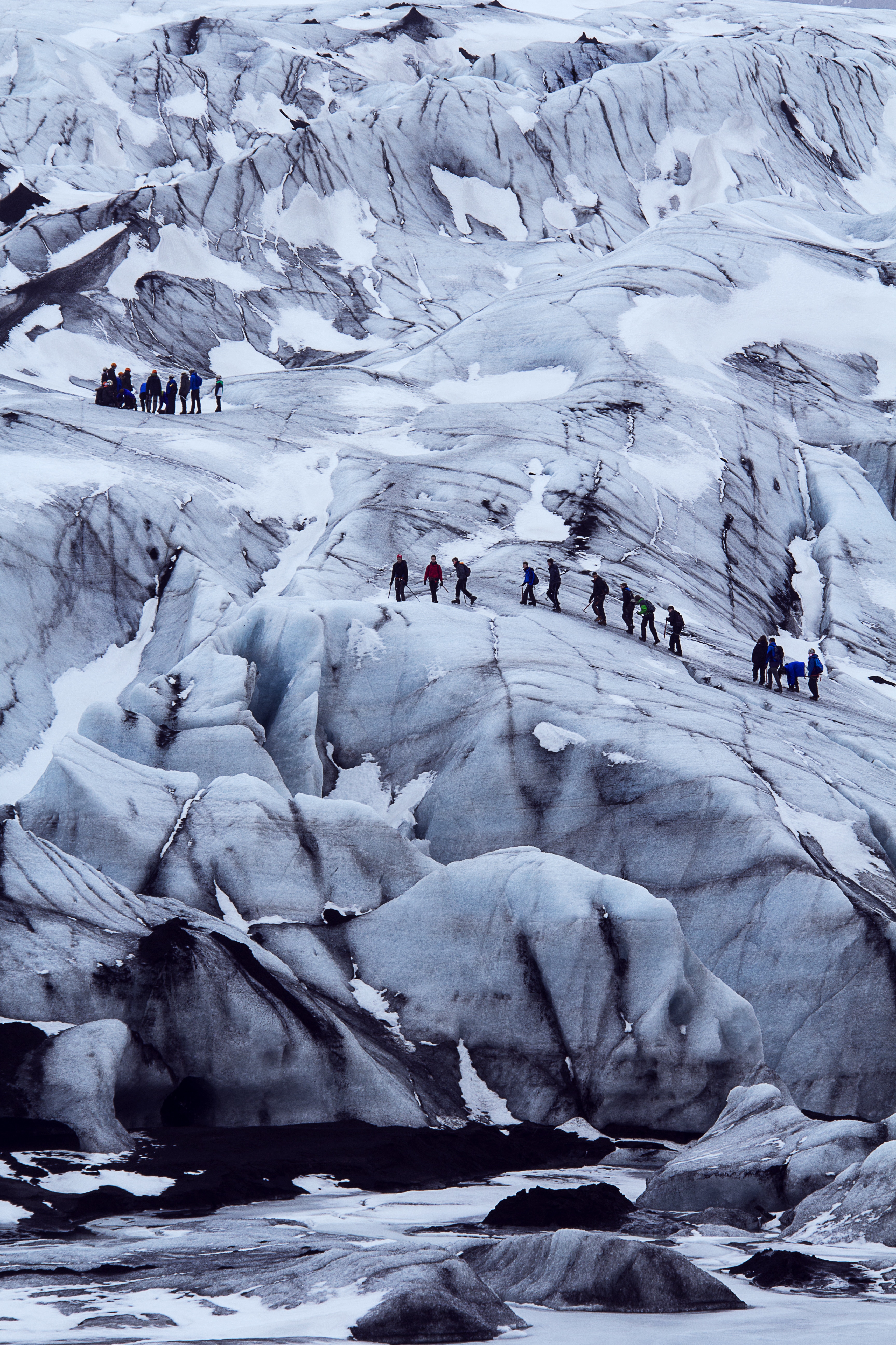 people on ice mountainn near body of water