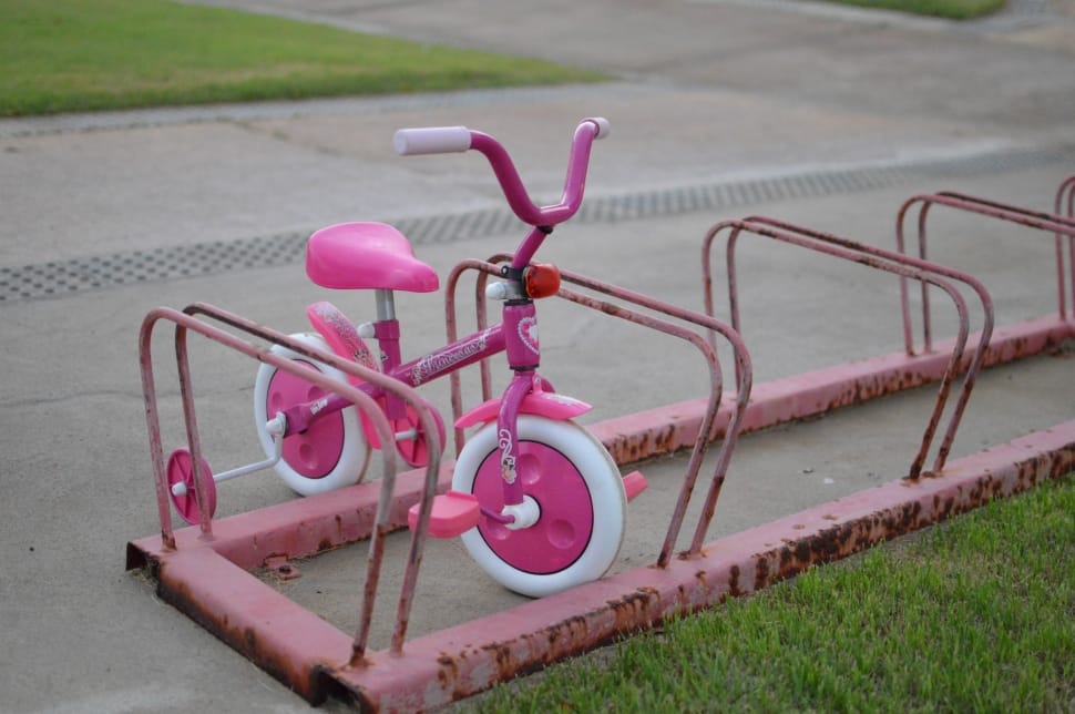 pink and white bicycle with training wheels preview