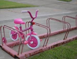 pink and white bicycle with training wheels thumbnail