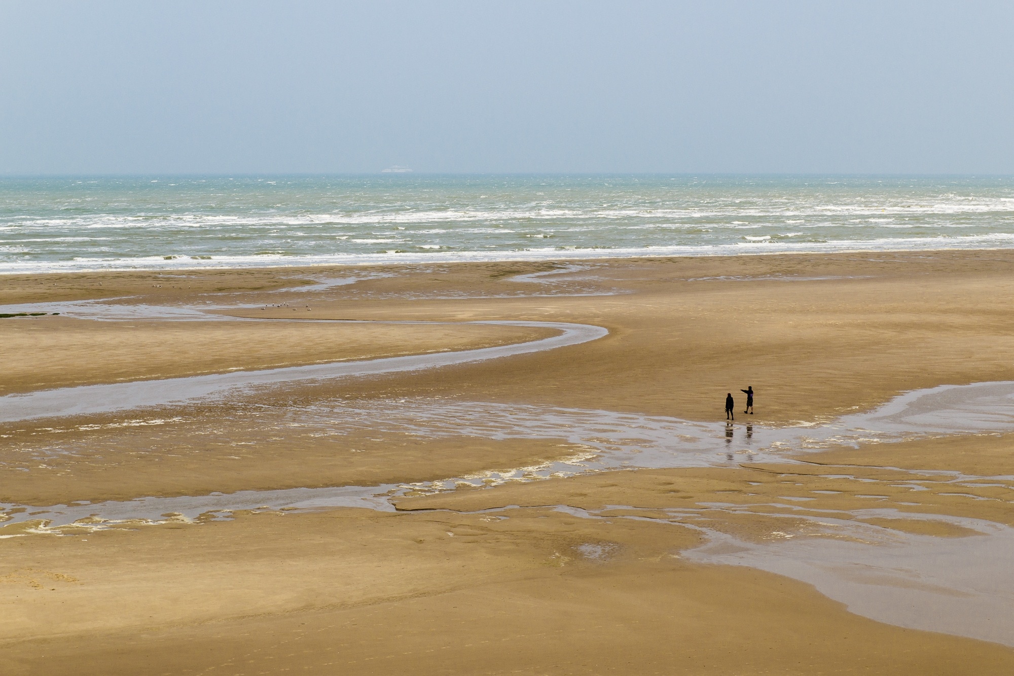 2 person standing on brown sand