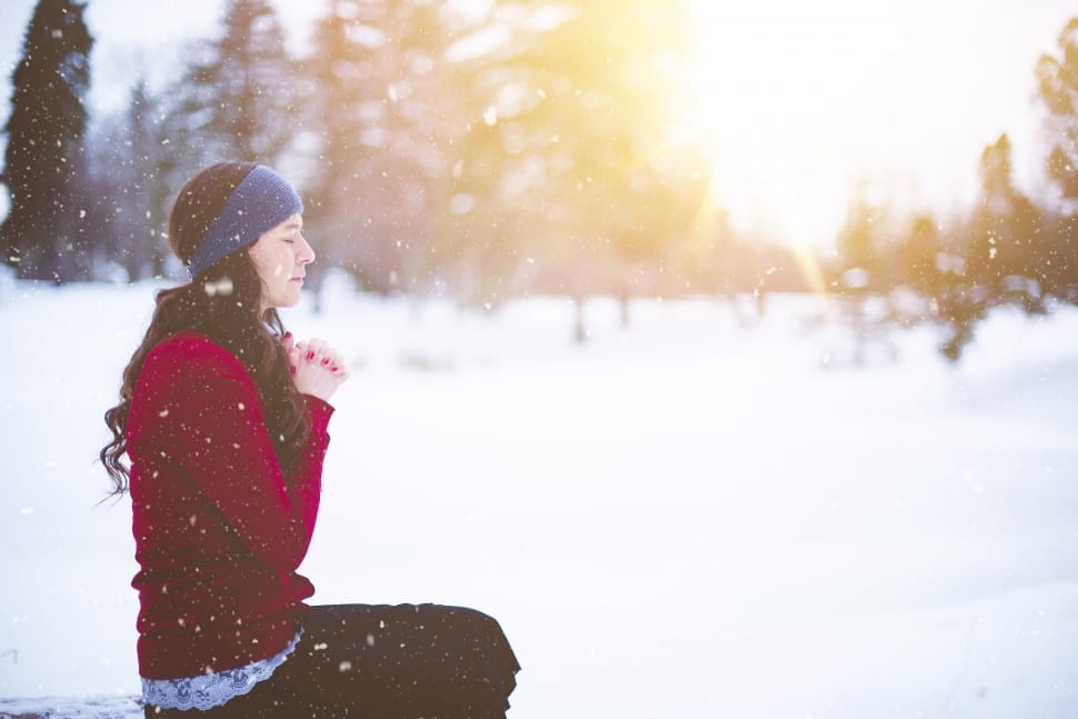 sitting woman wearing maroon sweater and blue headband during snowy season preview