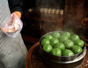 person in front of steamed green dumplings thumbnail