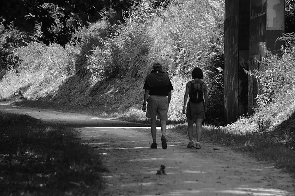 greyscale photo of woman and man walking preview