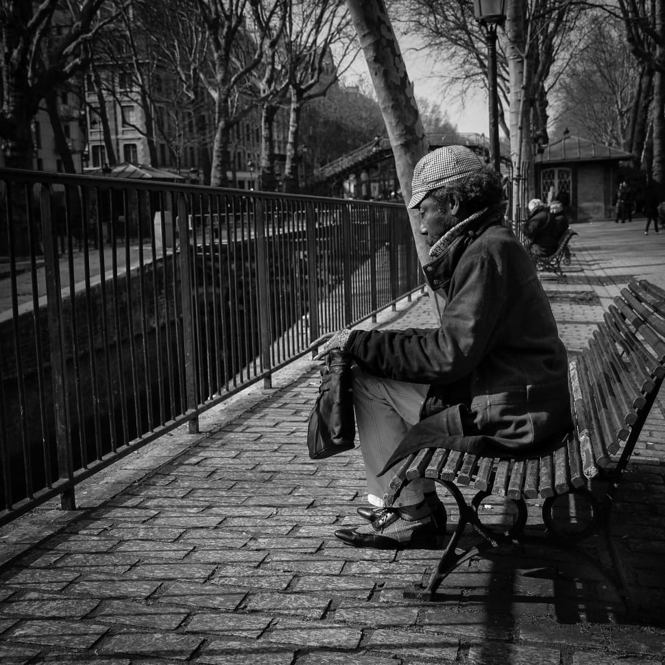 gray scale photo of man sitting on bench preview