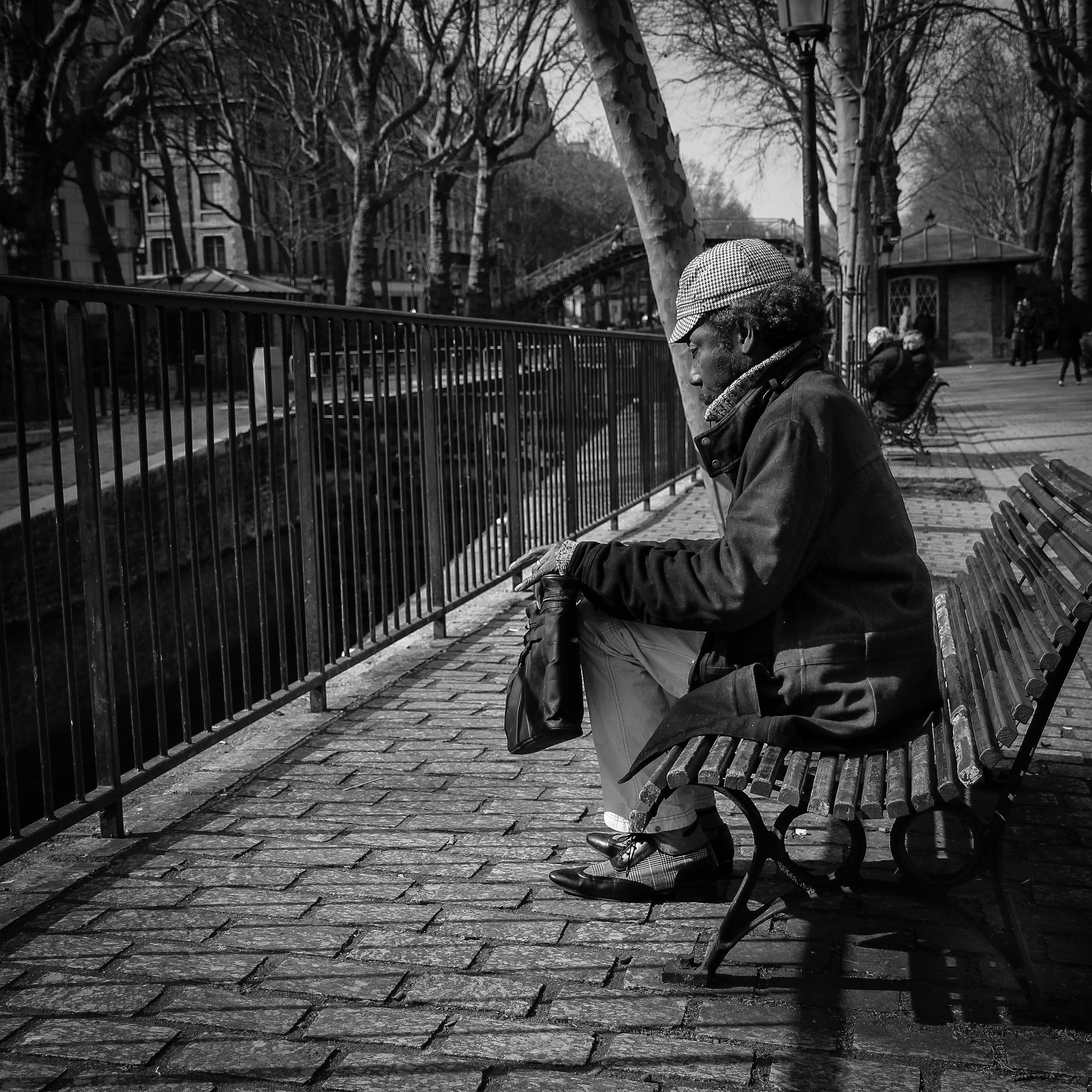 gray scale photo of man sitting on bench