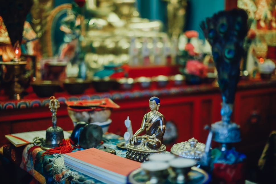 selective focus photograph of gold buddha figurine surround by various of items preview