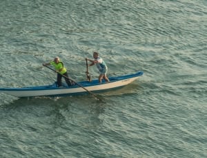 2 persons on blue and white canoe thumbnail