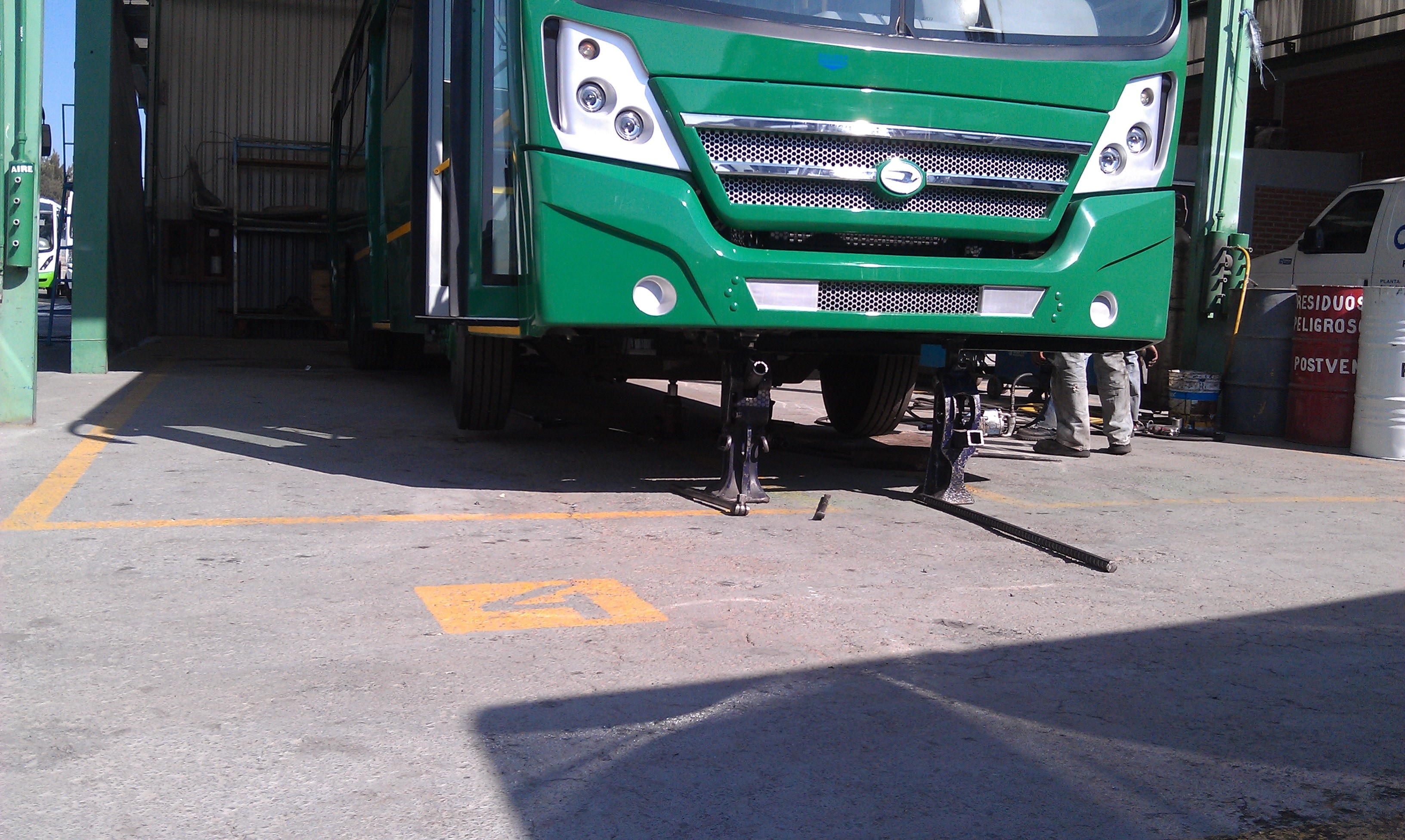two black scissor jack under of green bus during day time