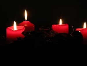 4 red lighted stick candles thumbnail