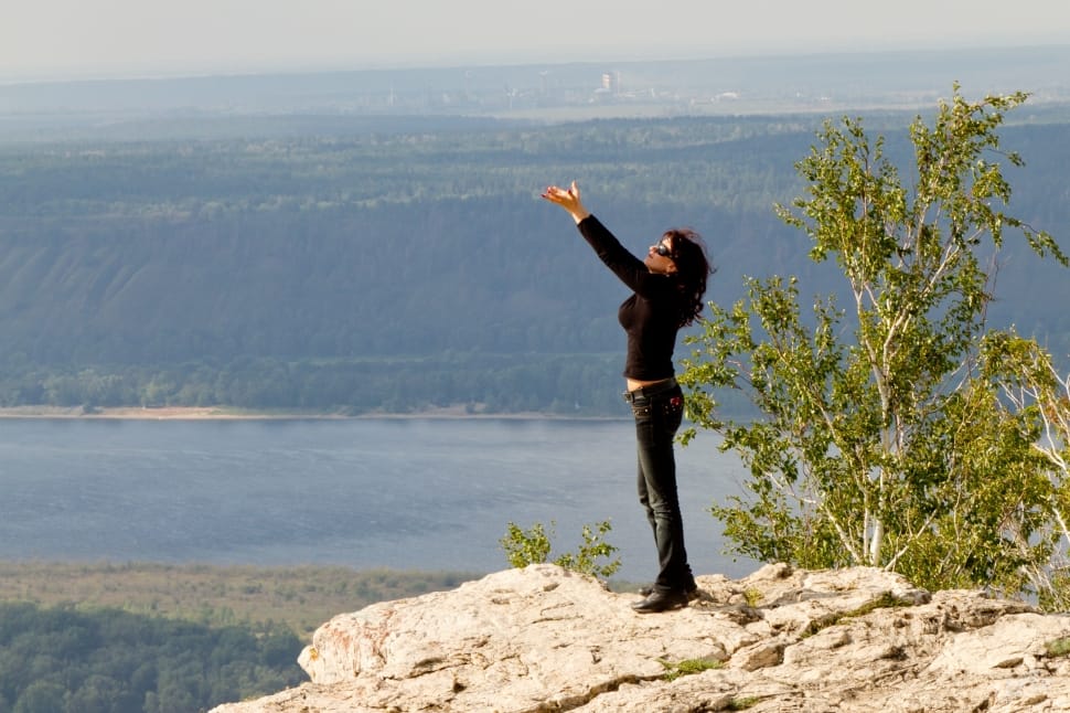 women in black long sleeves and pants standing on white rock formation preview