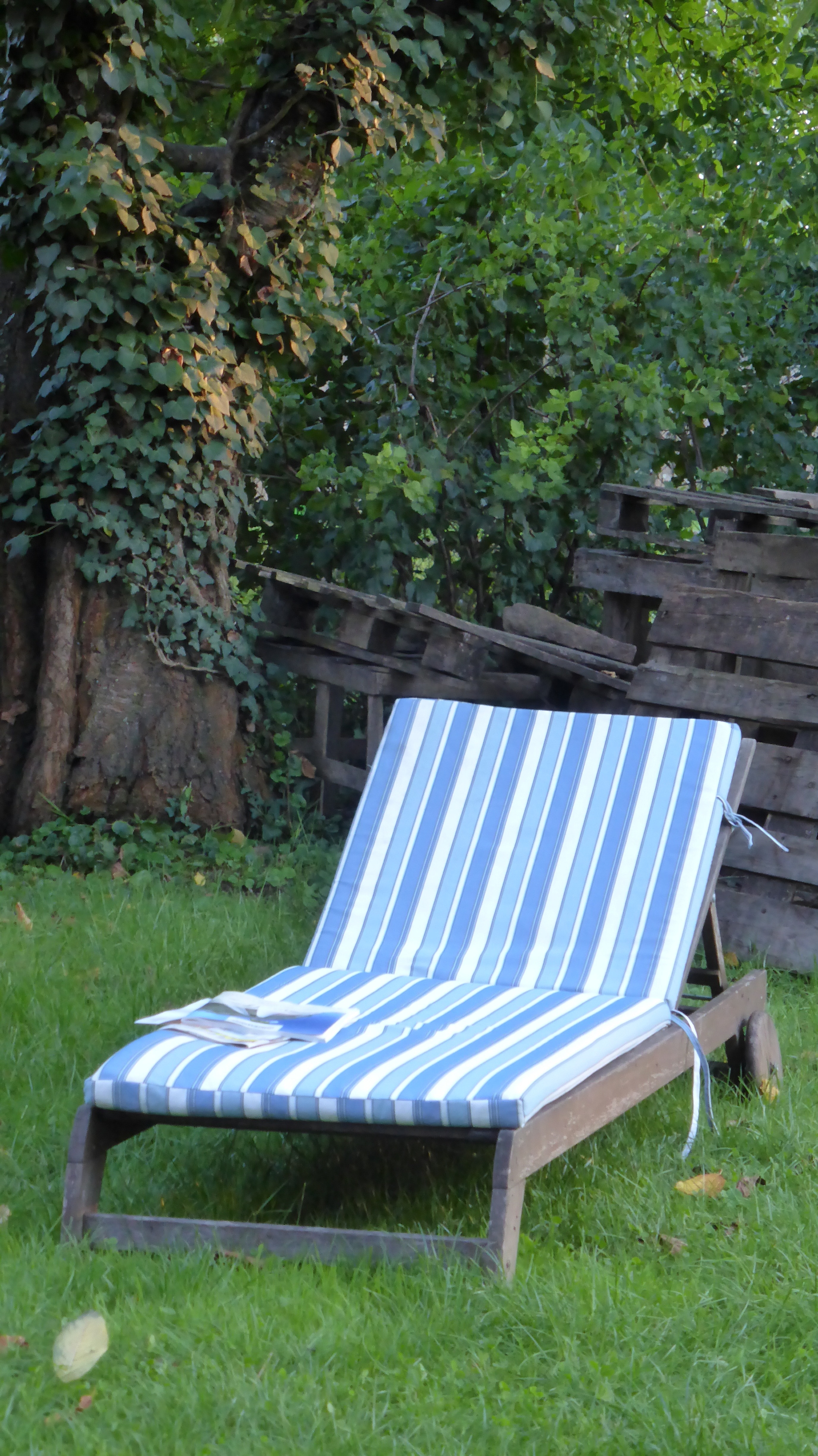 brown wooden framed blue white and teal striped foam padded lounger