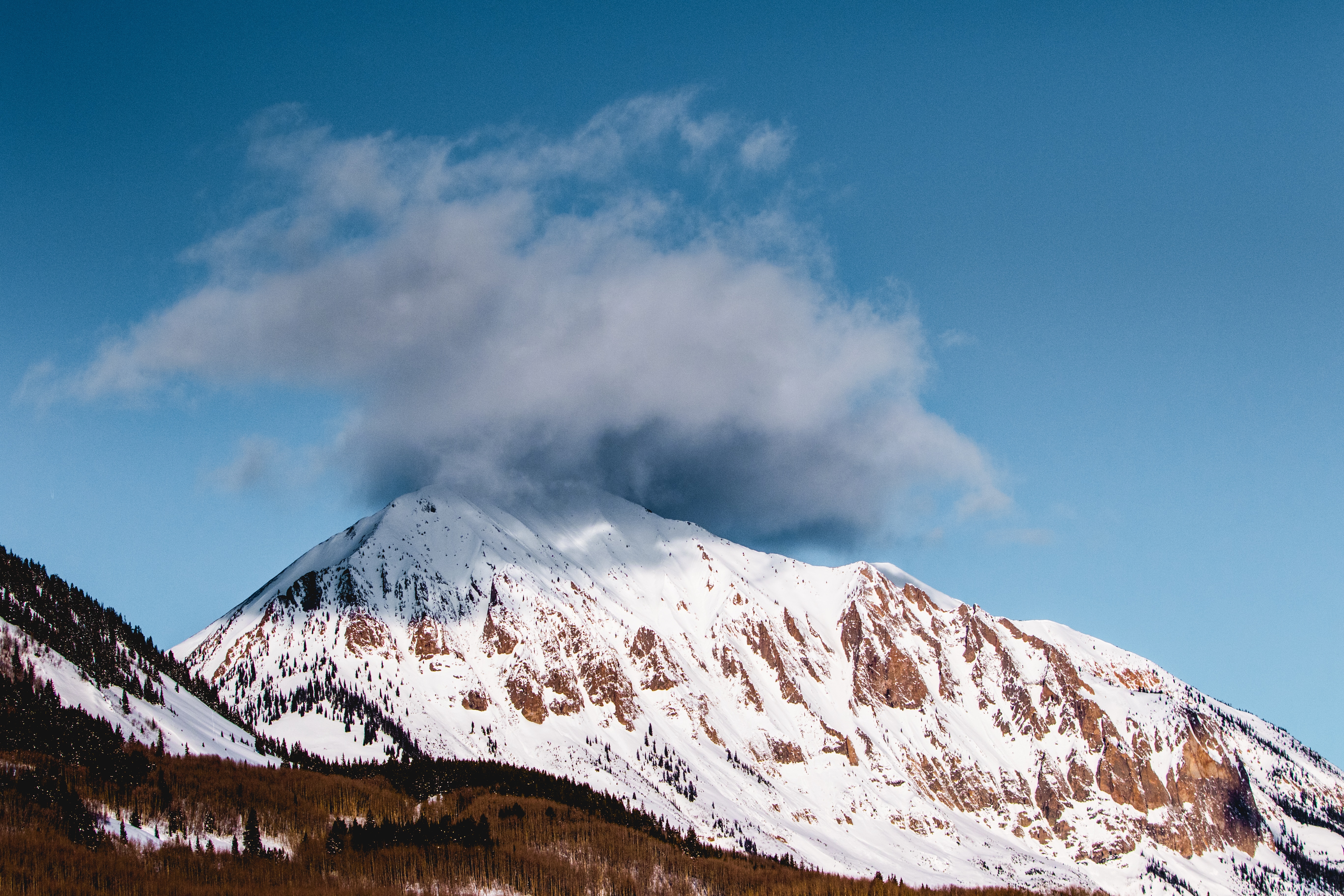 ice peak mountain covered with black clouds during daytime