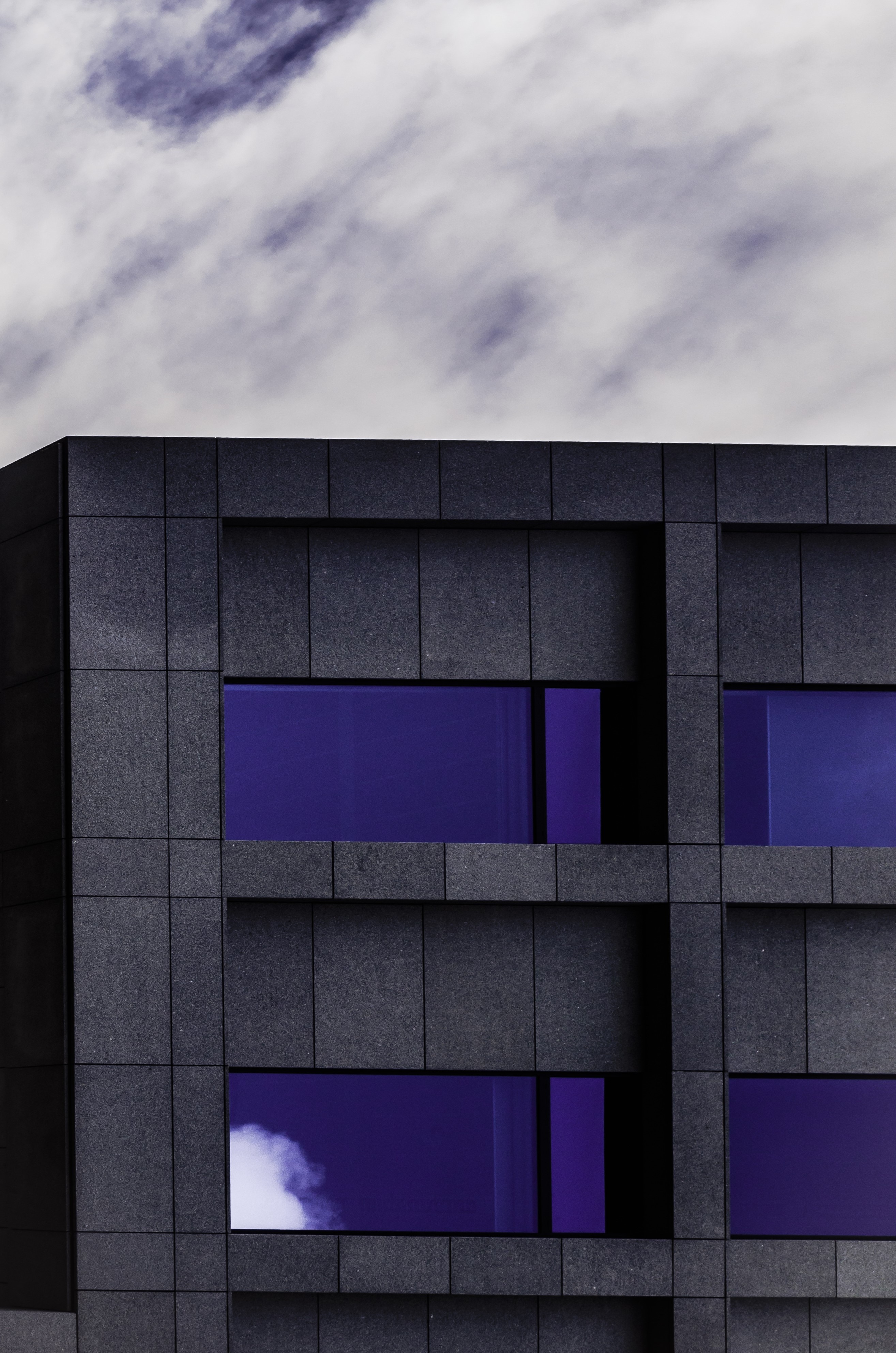 black concrete building with blue tinted glass windows